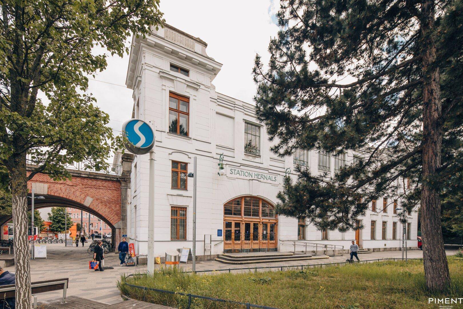 Historisches Gebäude der Station Hernals mit markanter Architektur und umliegender Grünfläche.