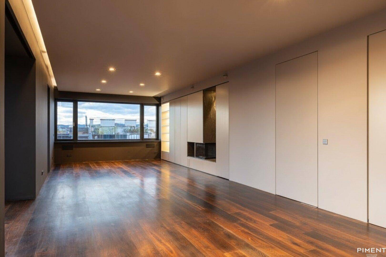Modernes Wohnzimmer mit dunklem Holzfußboden, integrierten Schränken, Kamin und weitem Stadtblick.