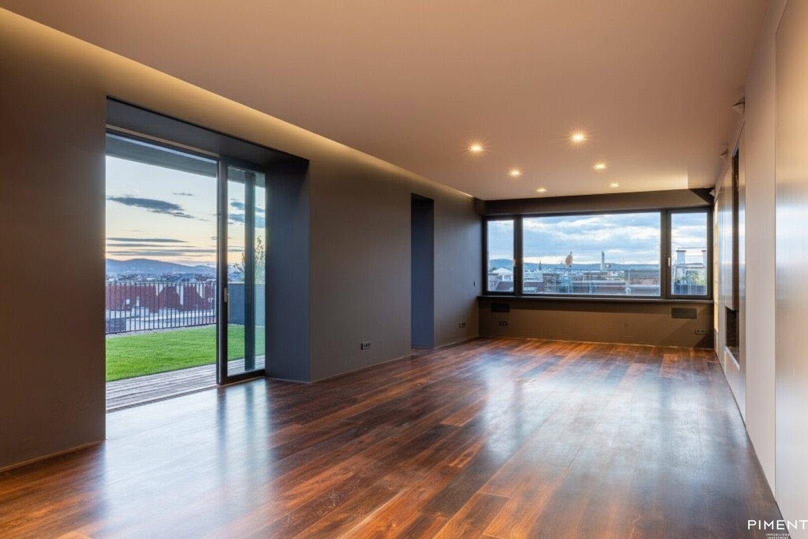Helles Wohnzimmer mit dunklem Holzfußboden, großen Fenstern und Zugang zur Dachterrasse mit Stadtblick.