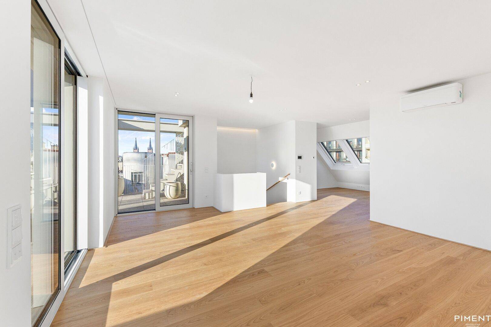 Geräumiger, heller Wohnbereich mit Holzboden, Terrassenzugang und Klimaanlage für angenehmes Klima.