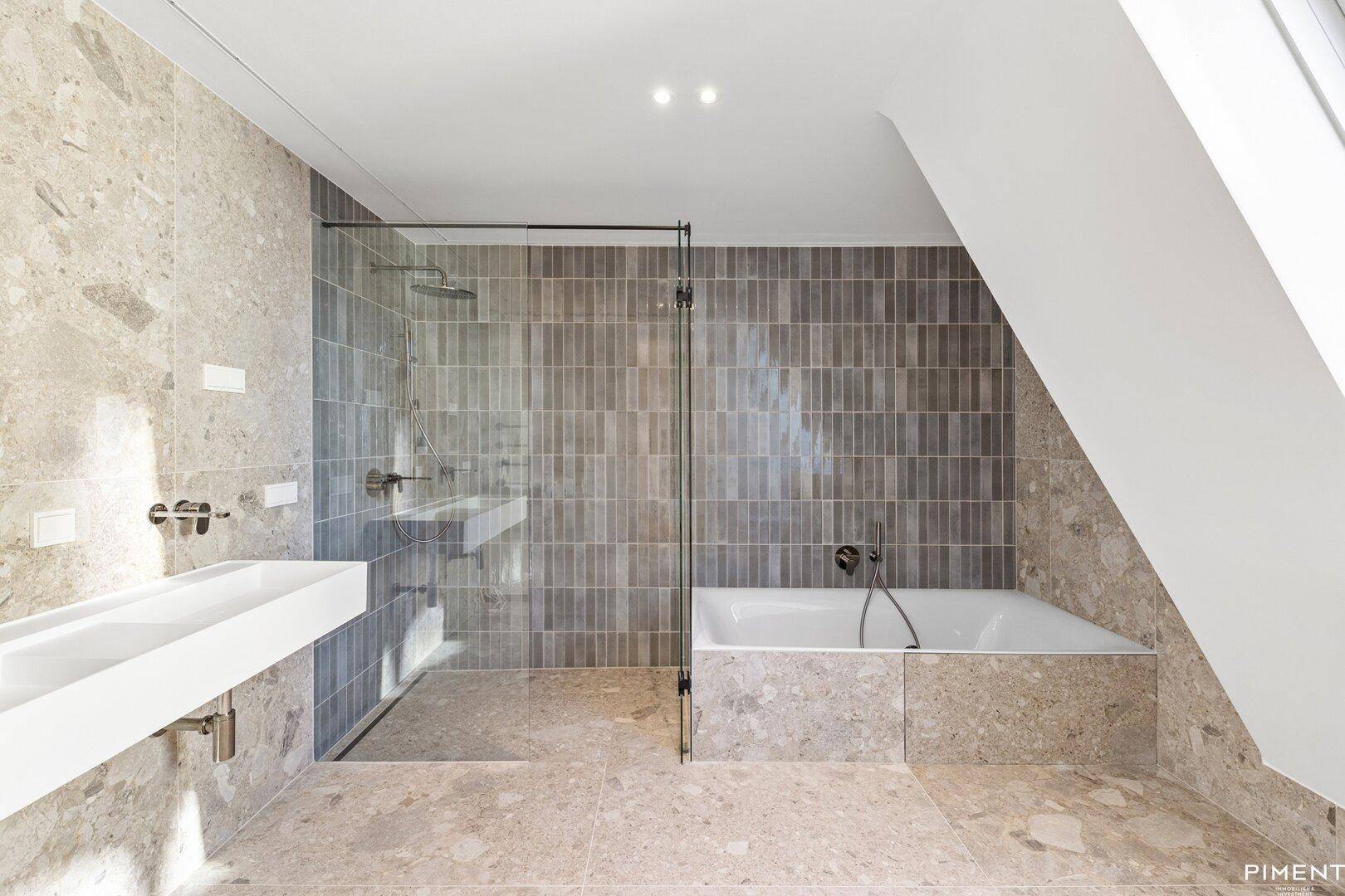 Modernes Badezimmer mit Fliesenboden, Badewanne und begehbarer Dusche unter Dachschräge.