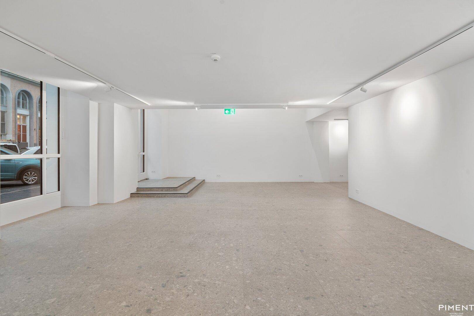 Weiterer Blick in den modernen Gewerberaum mit großen Fenstern und minimalistischer Gestaltung.