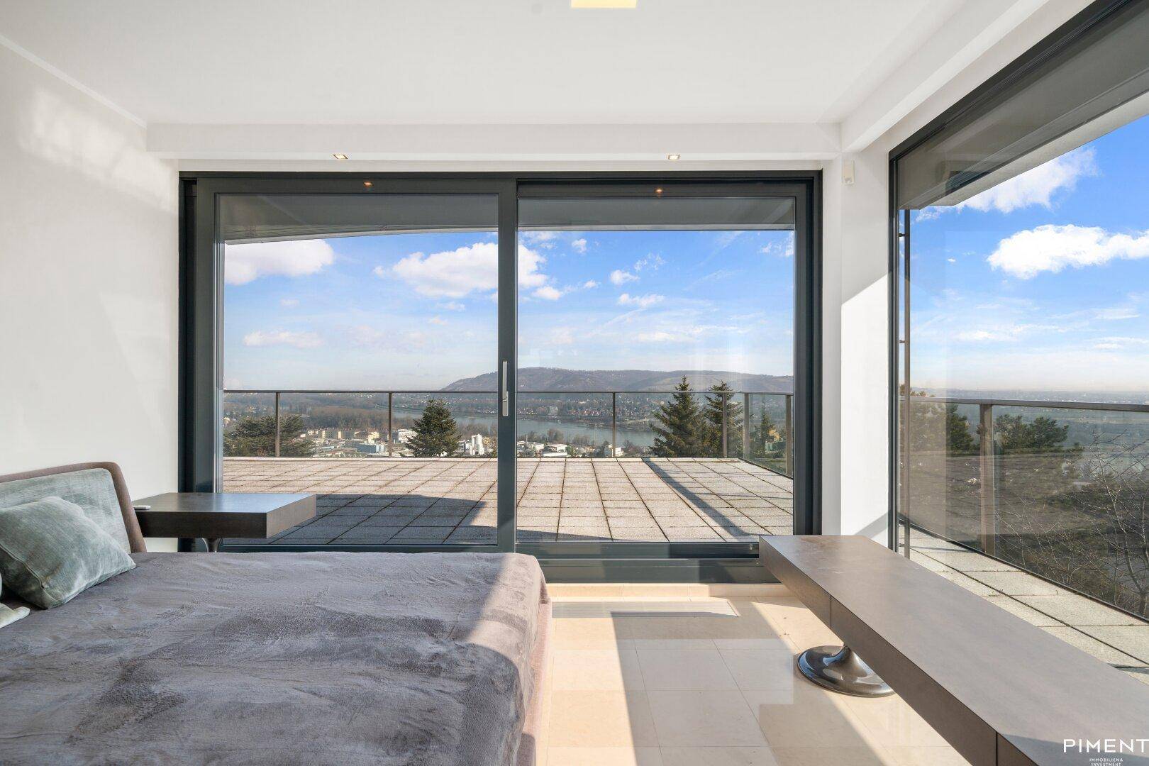 Schlafzimmer mit Zugang zu einer Terrasse und einem beeindruckenden Blick auf den Fluss und die umliegende Landschaft.