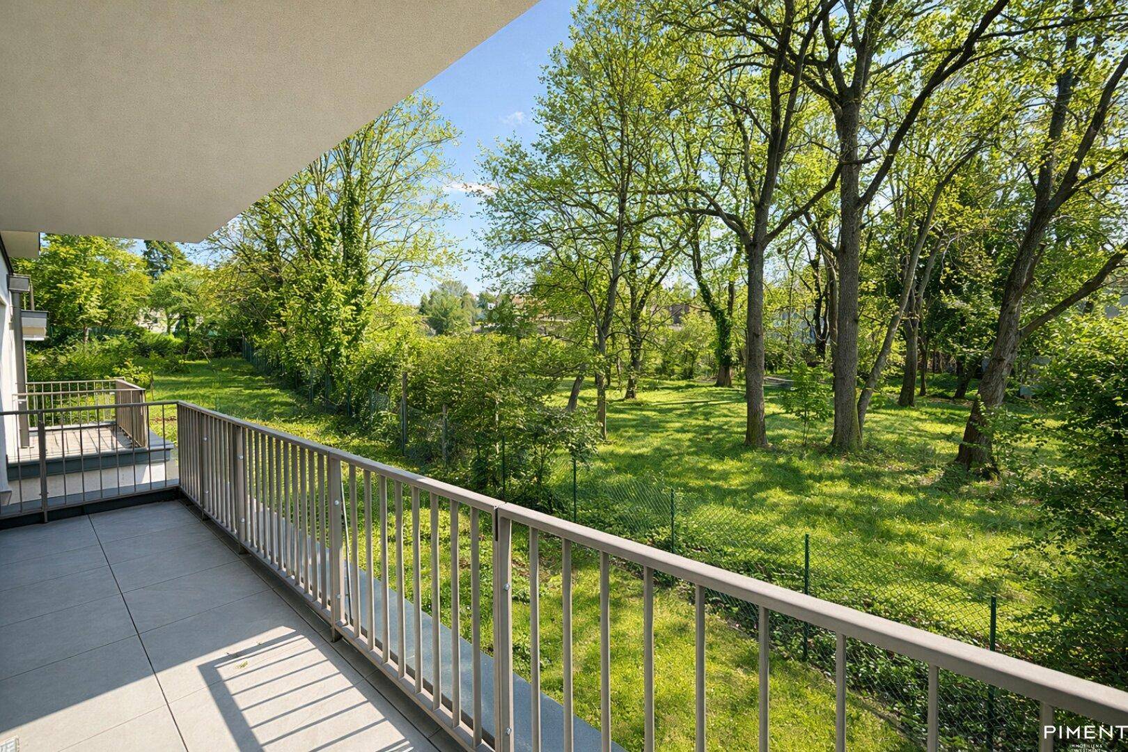 Geräumiger Balkon mit weitem Blick ins Grüne und alten Bäumen.