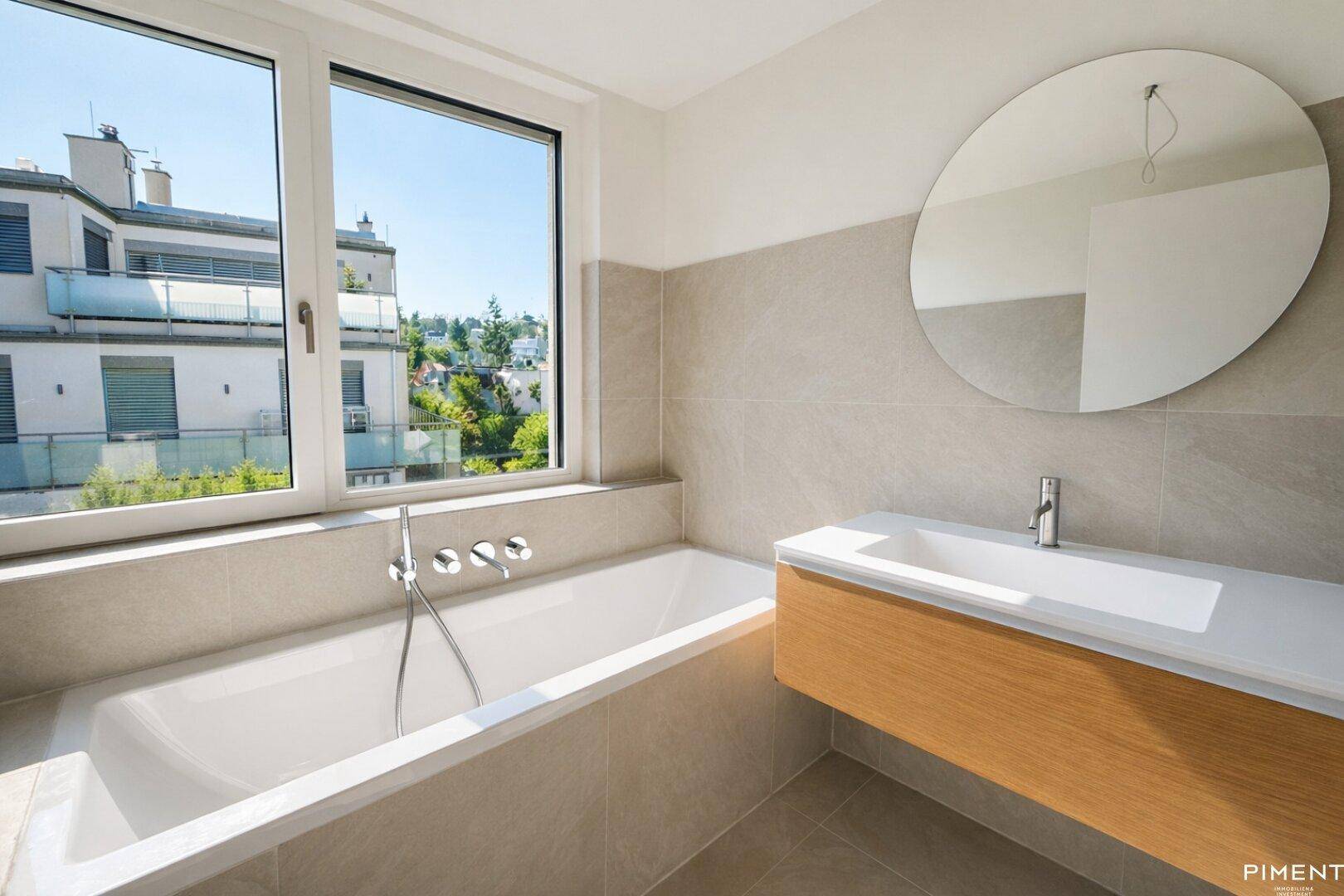 Modernes Badezimmer mit Badewanne, großem Fenster und schwebendem Waschtischunterschrank.