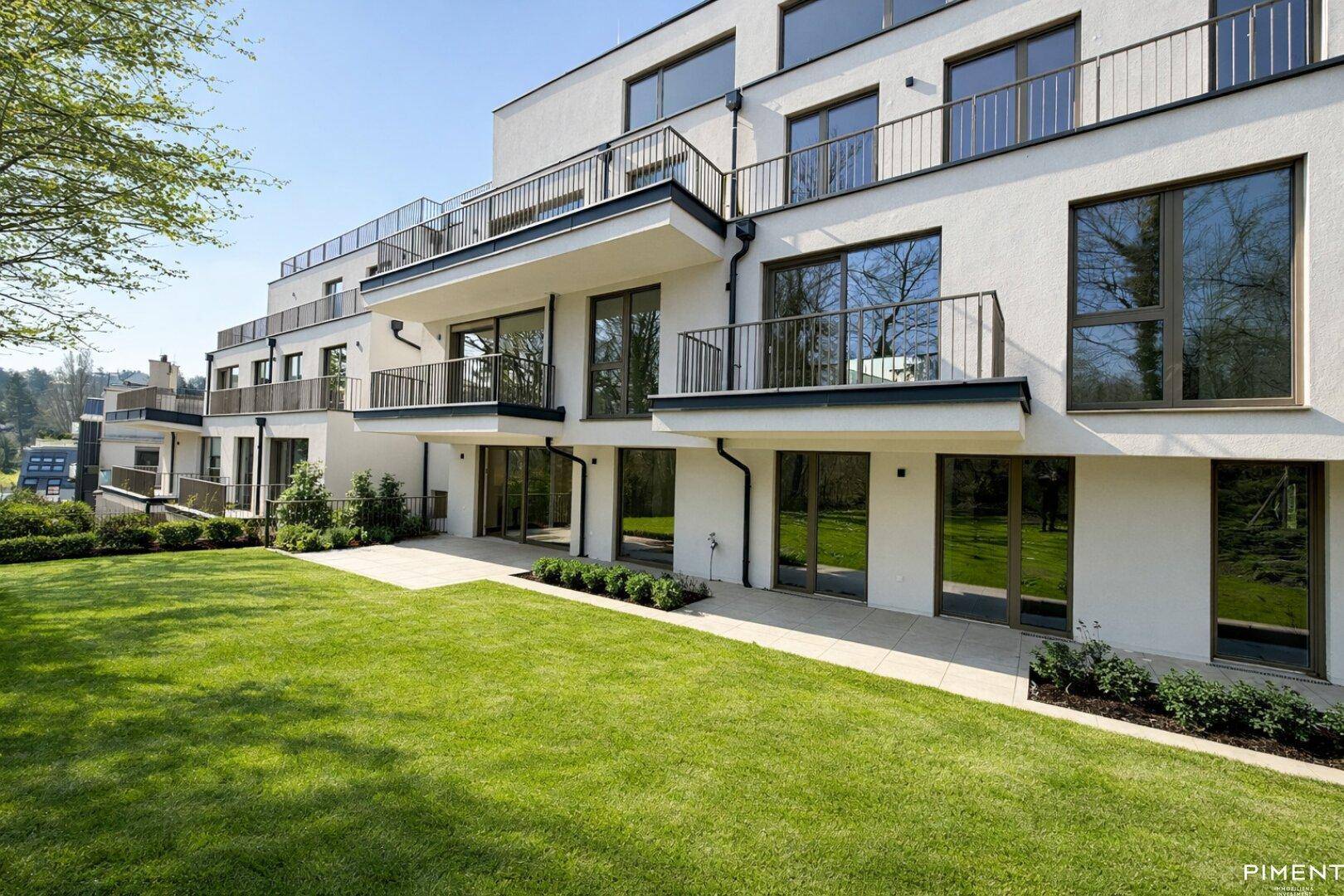 Moderne Wohnanlage mit mehreren Balkonen und einer weitläufigen Rasenfläche in ruhiger Umgebung.