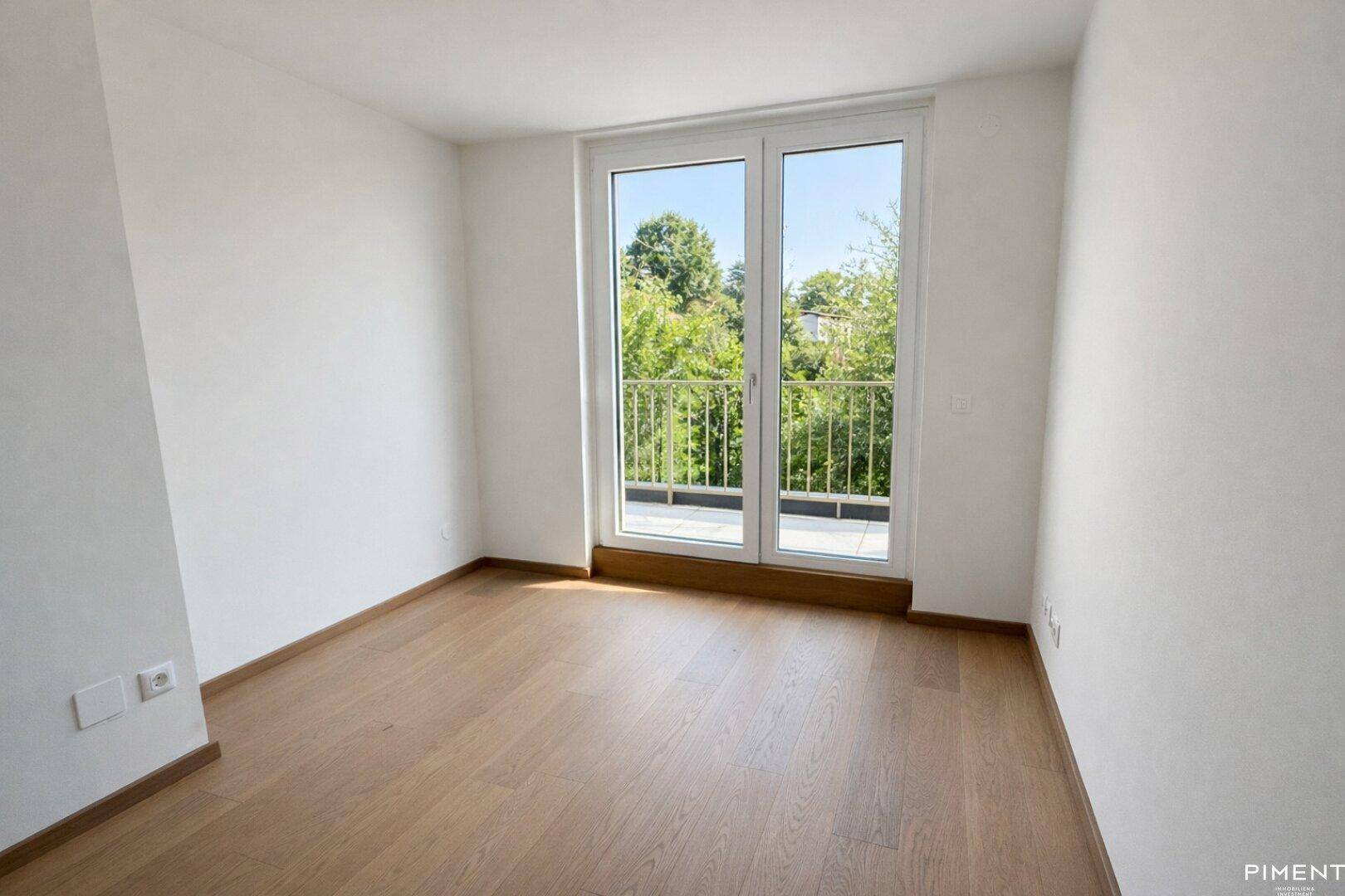 Geräumiges Schlafzimmer mit Parkettboden und großen Fenstern für viel Tageslicht.