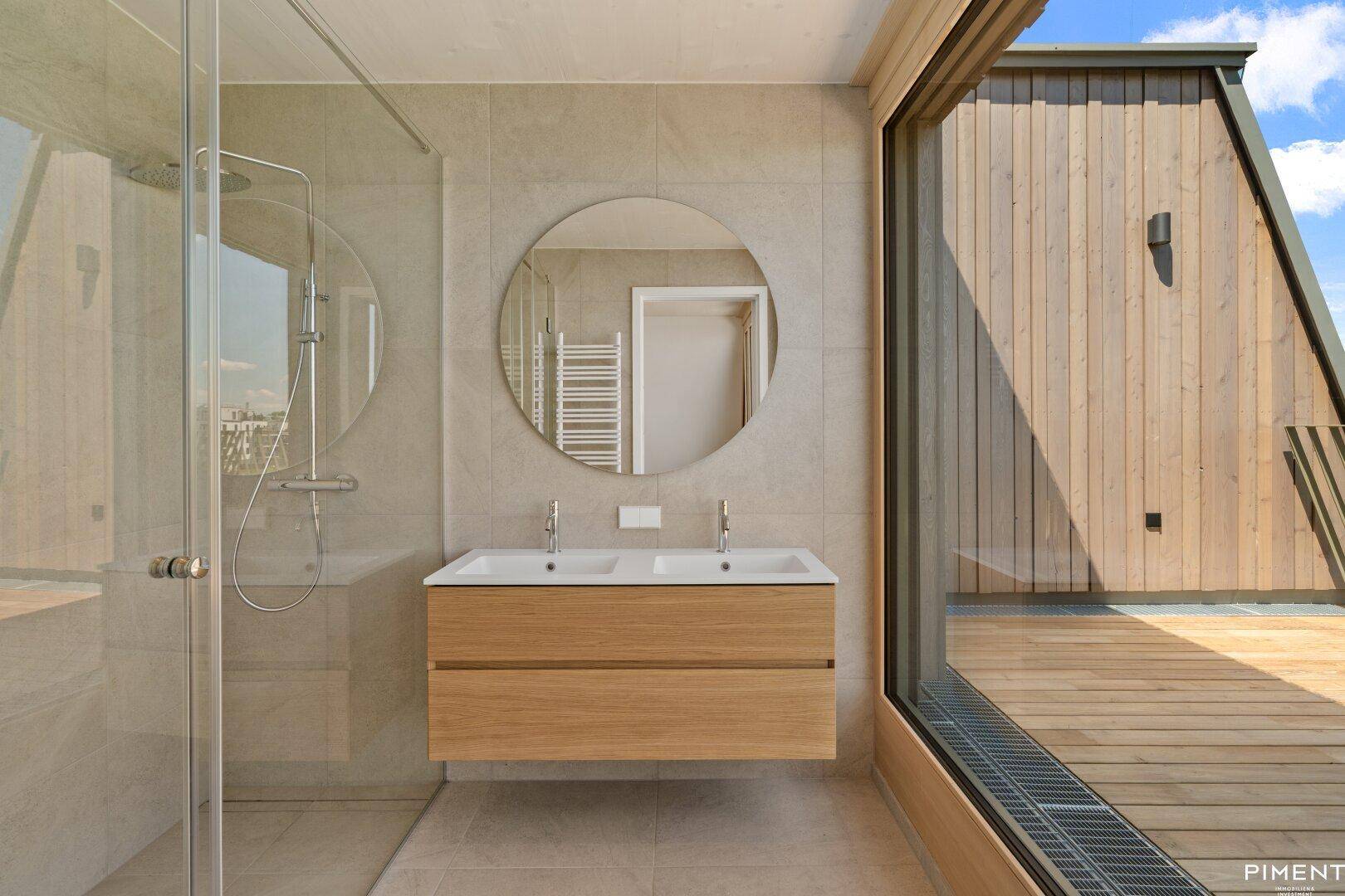 Modernes Badezimmer mit Doppelwaschbecken, großer Dusche und Blick auf die Terrasse.