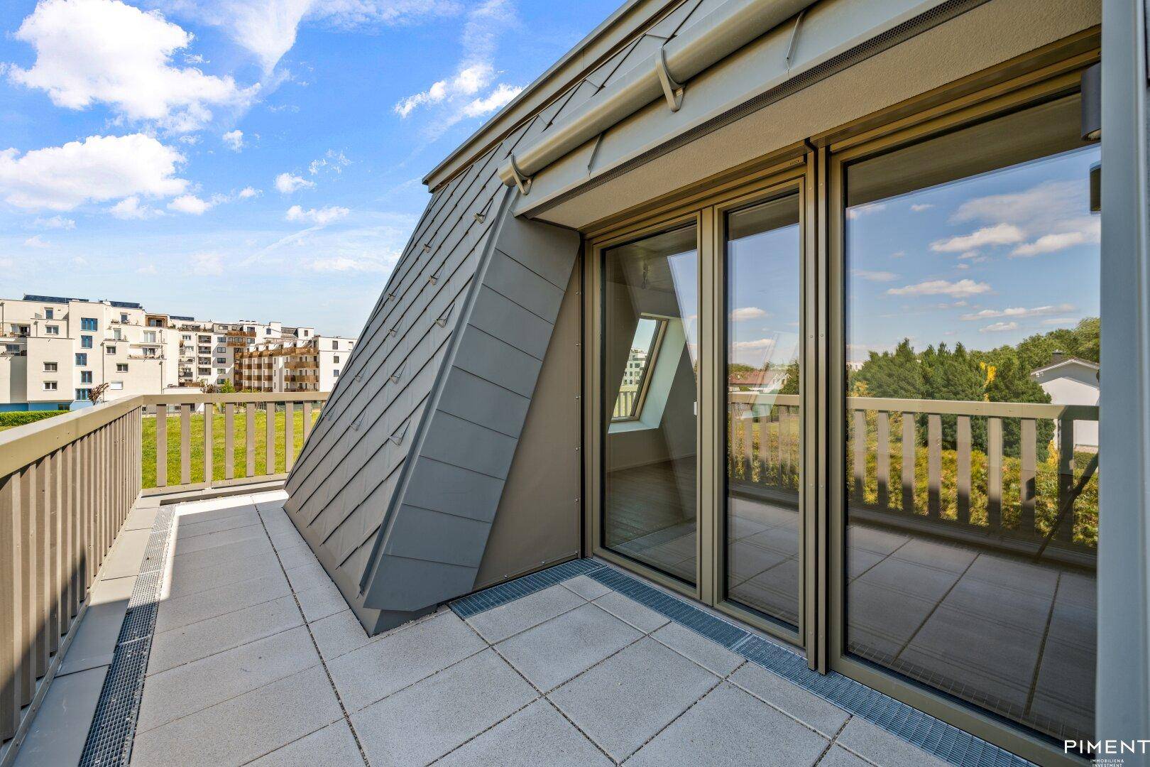 Geräumige Dachterrasse mit Fliesenboden und Blick auf die umliegenden Gebäude.