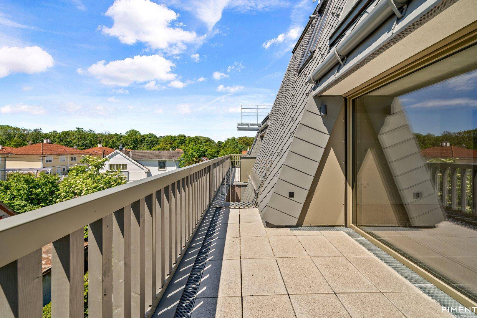 Geräumige Dachterrasse mit moderner Architektur und Blick auf die Umgebung.