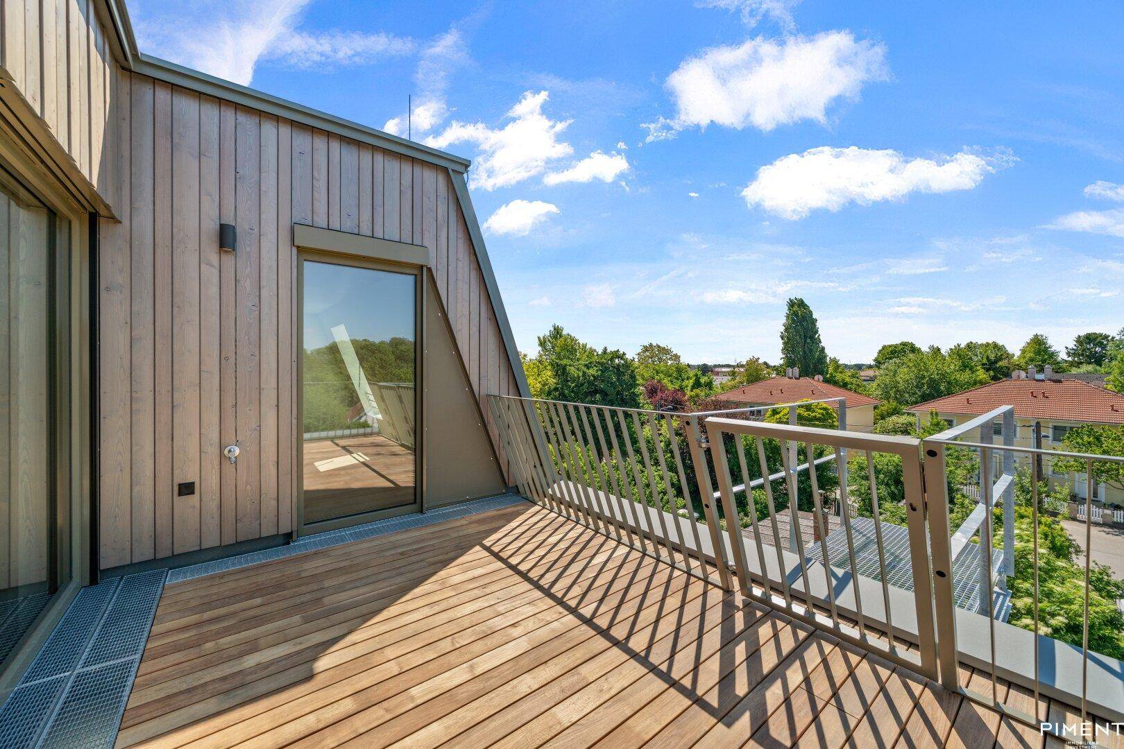 Moderner Holzbalkon mit Holzfassade und Metallgeländer, bietet einen weiten Blick.
