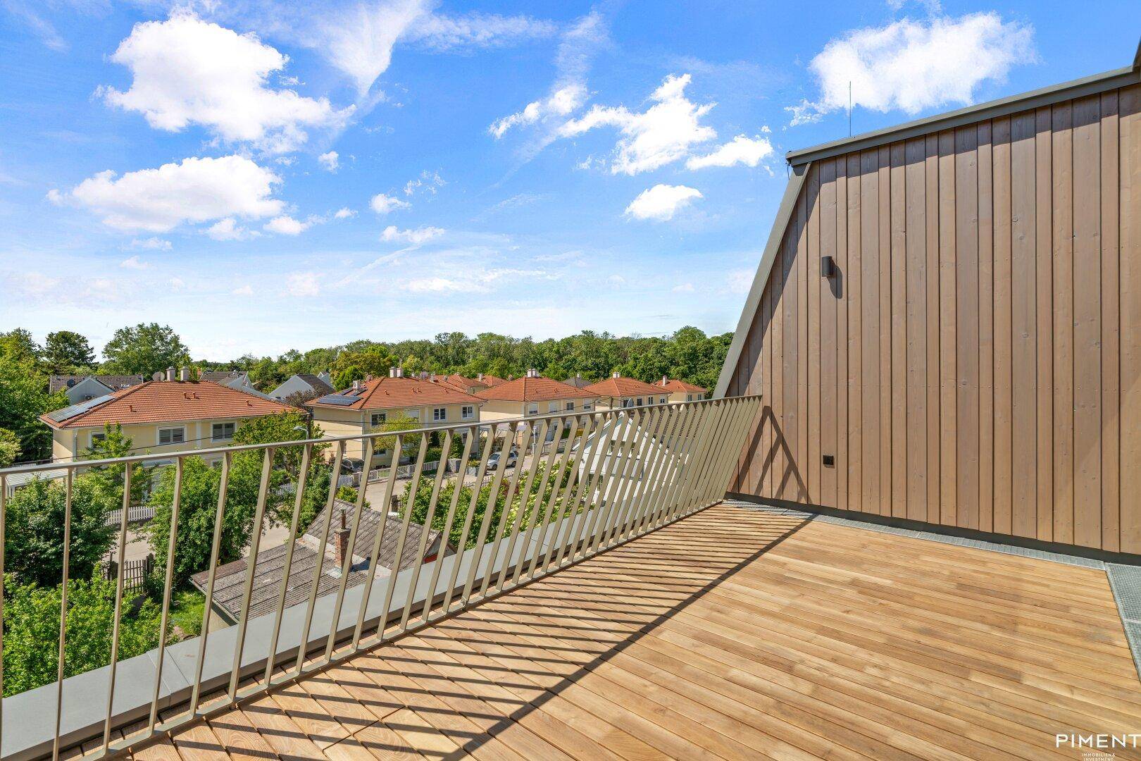 Geräumige Holzterrasse mit modernem Geländer und Panoramablick auf die Umgebung.