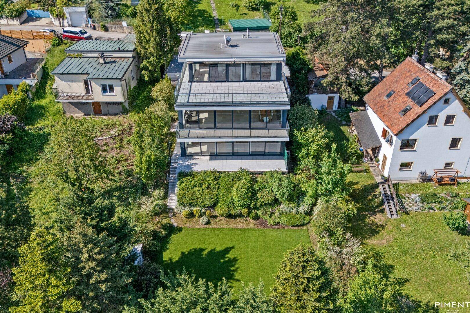 Luftaufnahme des modernen Anwesens mit gepflegtem Rasen und umgebender grüner Landschaft.