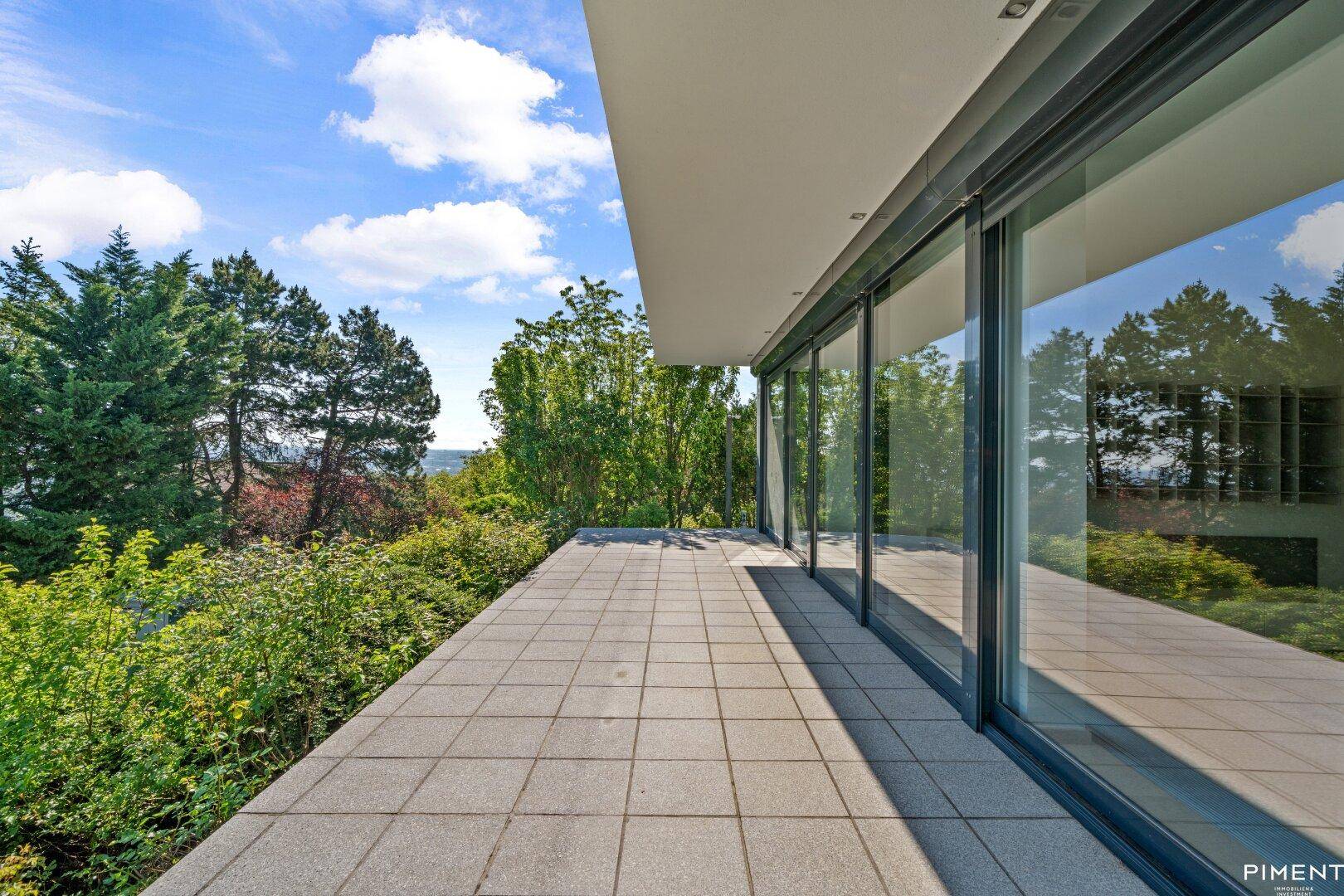 Großzügige Terrasse im Erdgeschoss mit Steinplatten und direktem Zugang zum Gartenbereich des Hauses.