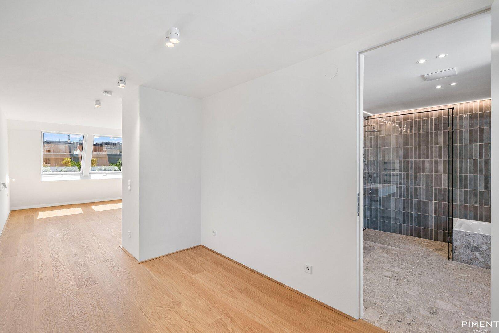 Heller Flurbereich mit Holzboden und Blick in ein modernes Badezimmer.