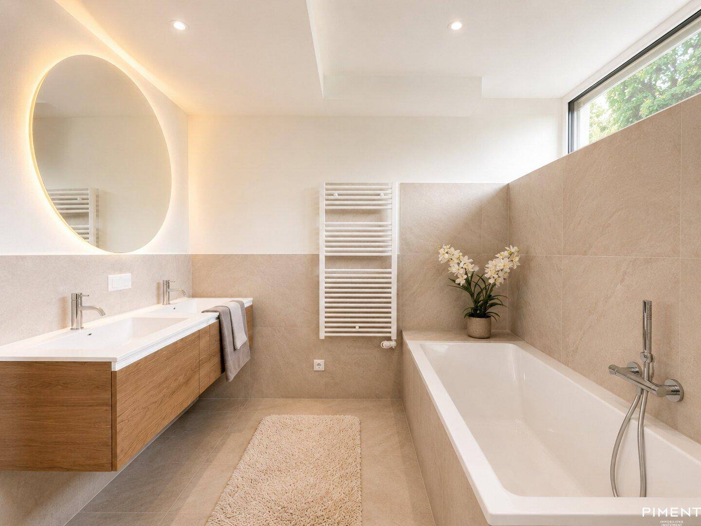 Modernes Badezimmer mit Badewanne, Doppelwaschbecken und beheiztem Handtuchhalter.