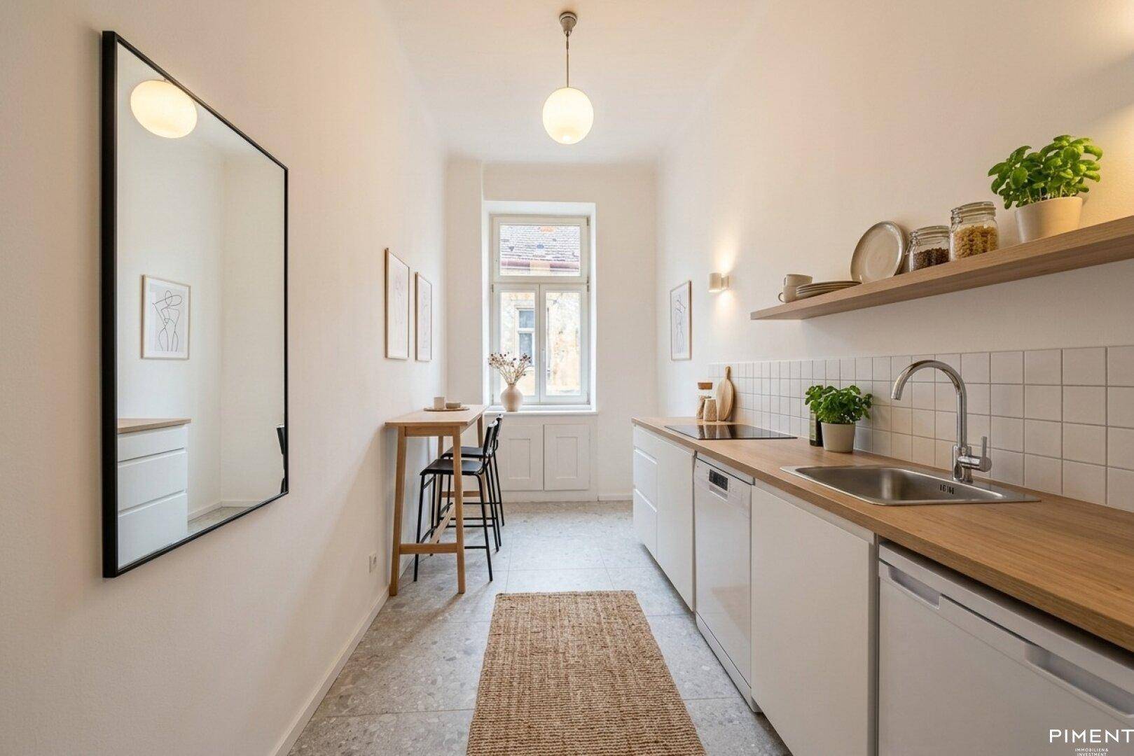Schmale, moderne Küche mit weißen Schränken, Holzarbeitsplatte und Fenster.