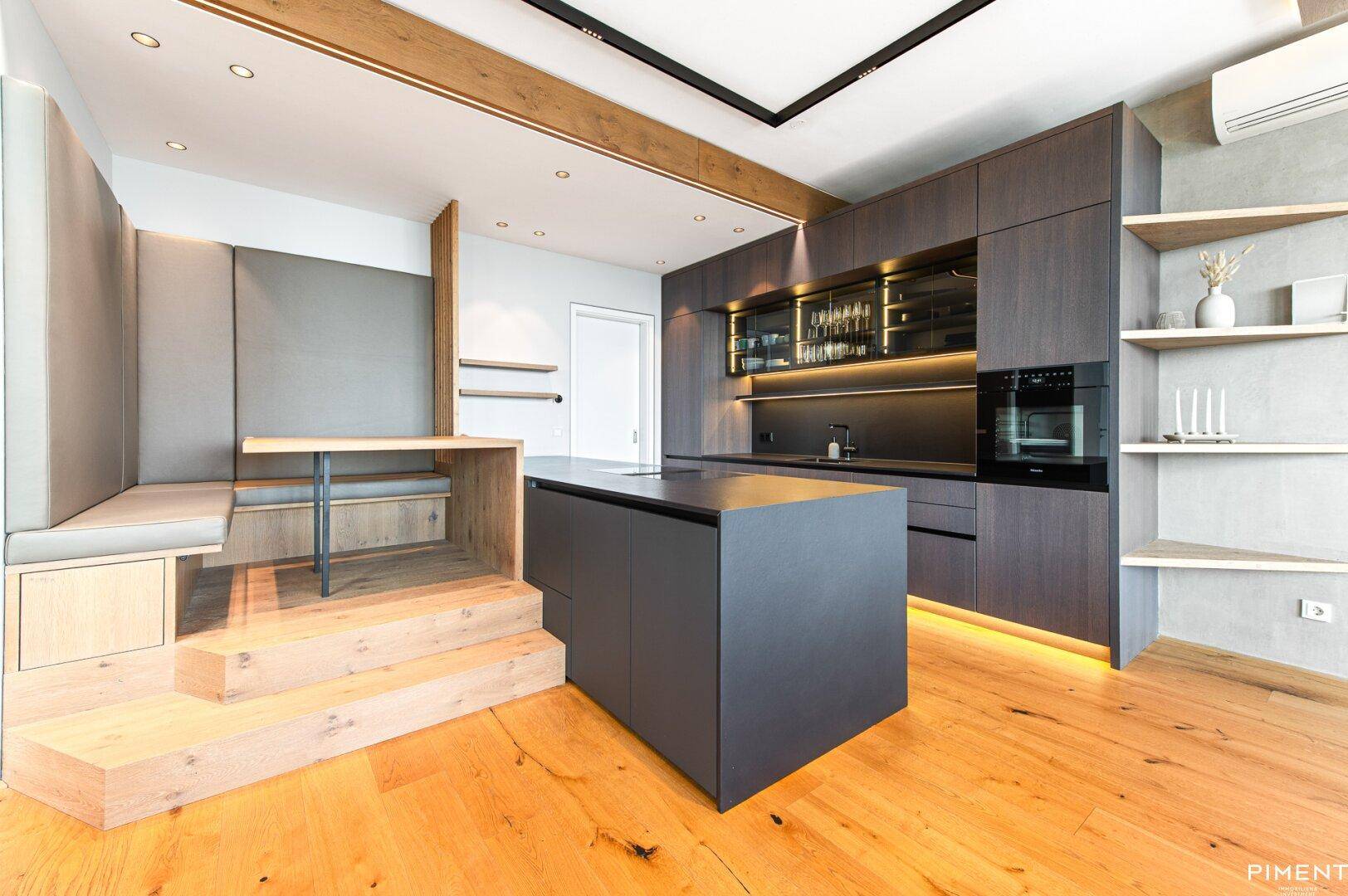 Moderne Küche mit integrierter Sitzecke und Holzelementen, ideal für gemütliche Mahlzeiten.