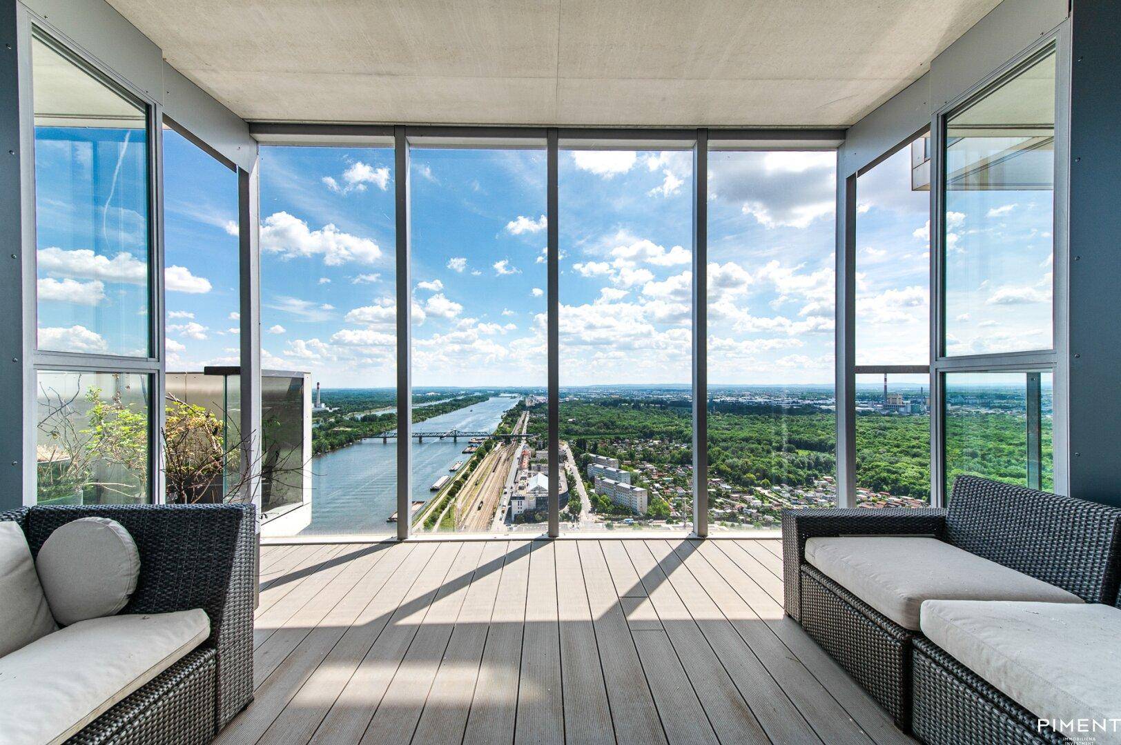 Geräumige Terrasse mit bequemen Loungemöbeln und atemberaubendem Weitblick über den Fluss und die Stadt.