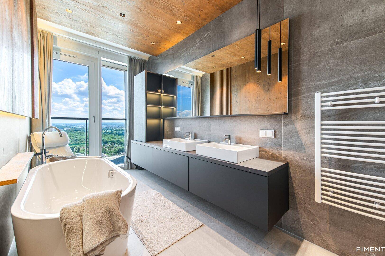 Luxuriöses Badezimmer mit freistehender Badewanne, Doppelwaschbecken und Panoramablick.