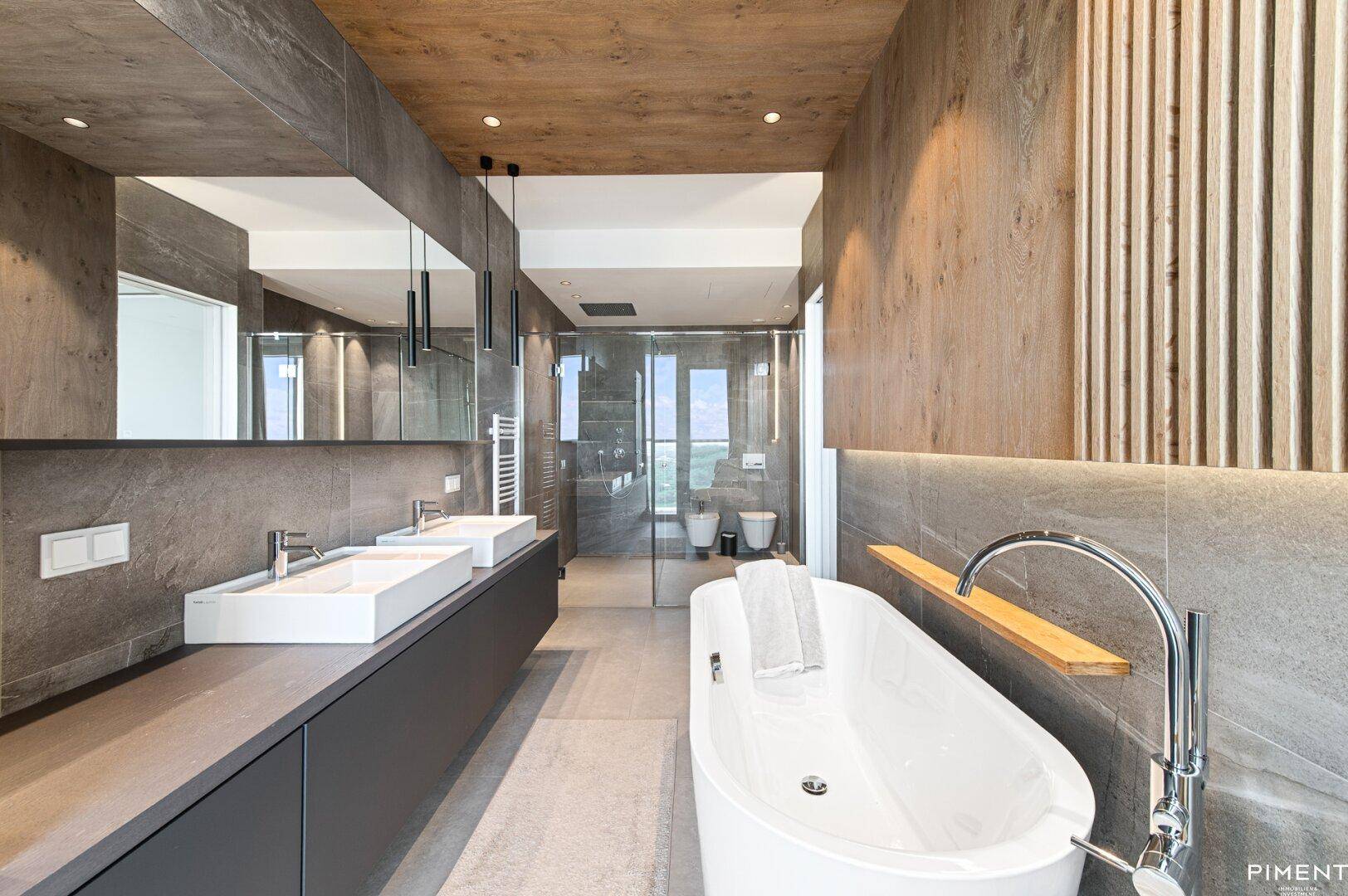 Elegantes Badezimmer mit freistehender Badewanne, Doppelwaschbecken und großer begehbarer Dusche.