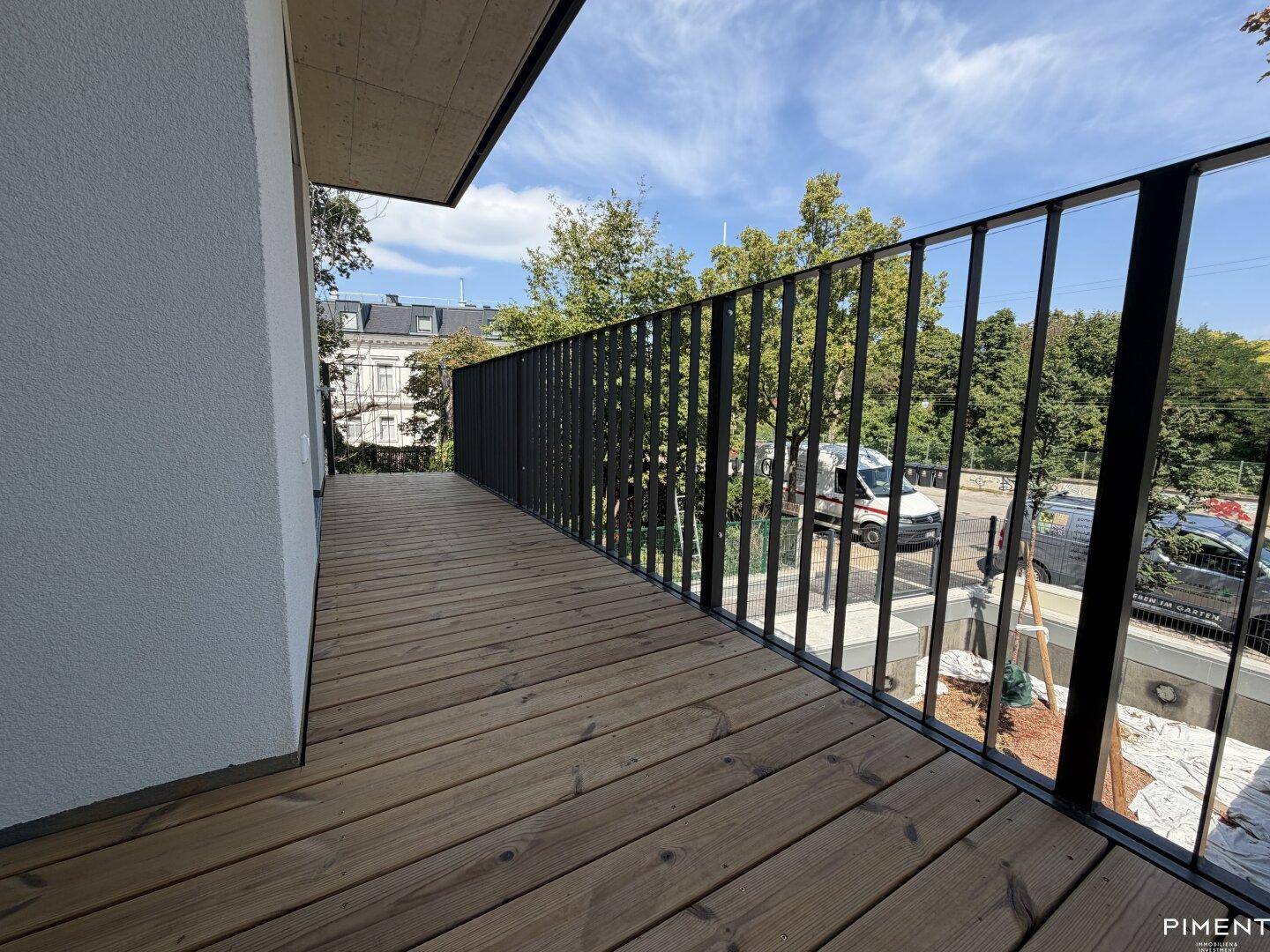 Langer Balkon mit Holzboden und Blick auf die Straße, bietet zusätzlichen Außenbereich.