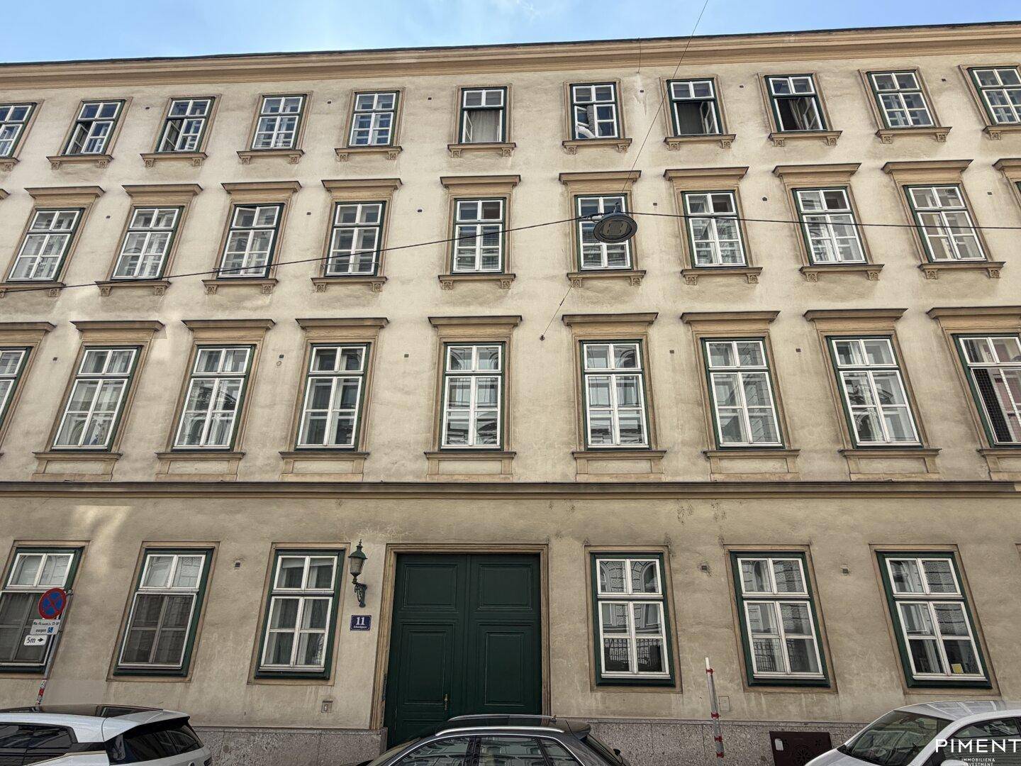 Klassische Fassade eines Mehrfamilienhauses mit vielen Fenstern und traditioneller Architektur.