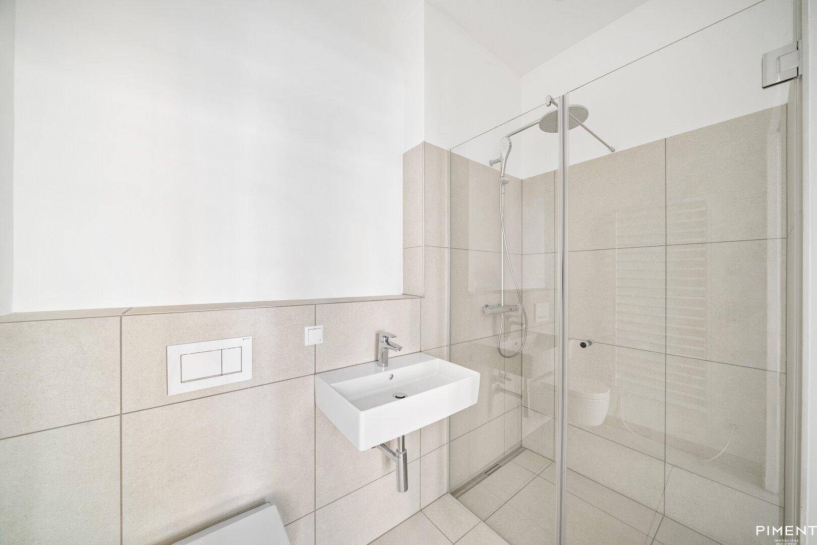 Modernes Badezimmer mit begehbarer Dusche, Wand-WC und beigefarbenen Fliesen.