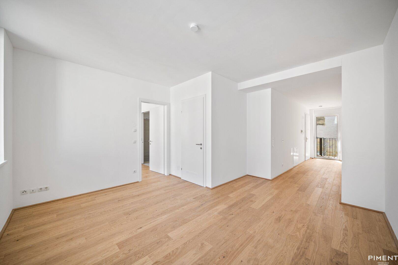 Geräumiger, heller Flur mit Holzboden und Zugang zu weiteren Zimmern der Wohnung.