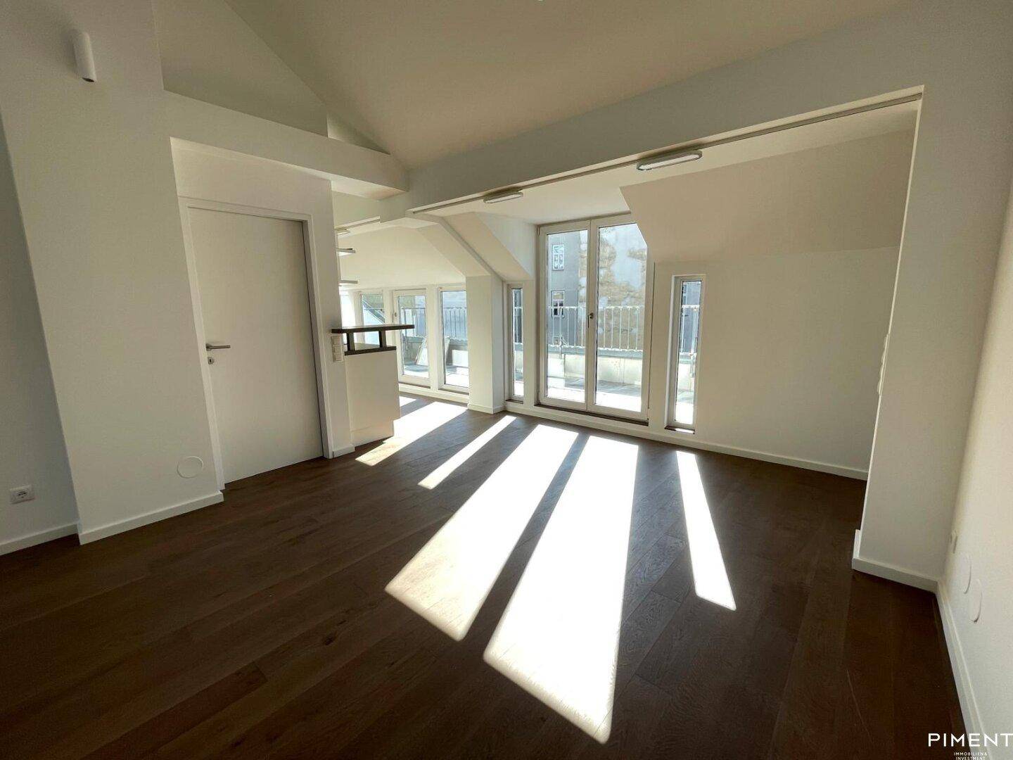 Heller Wohnbereich mit Holzboden, großen Fenstern und viel Tageslicht, ideal zum Entspannen.