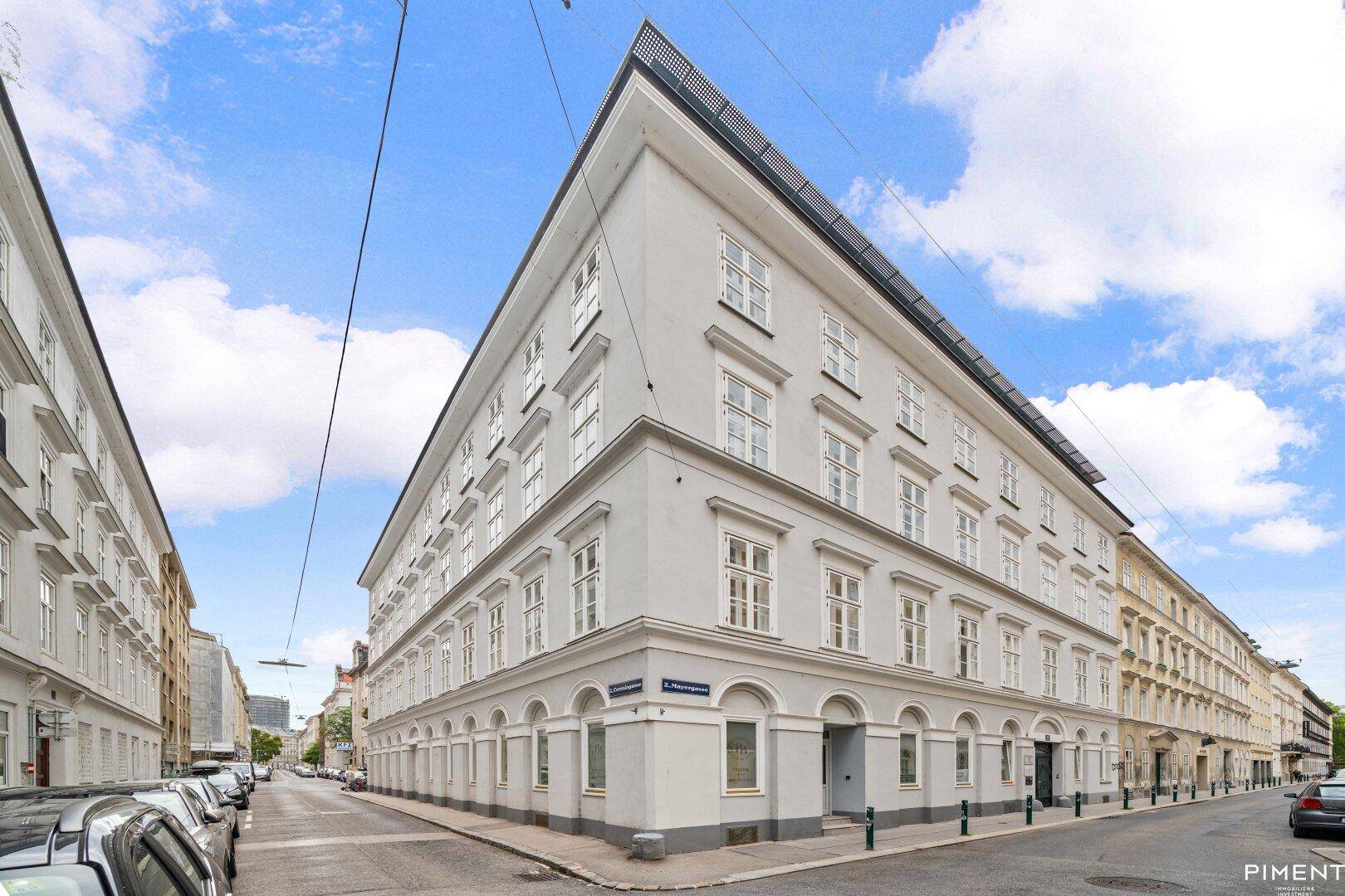 Historisches Eckgebäude mit eleganter Fassade und vielen Fenstern in urbaner Umgebung.