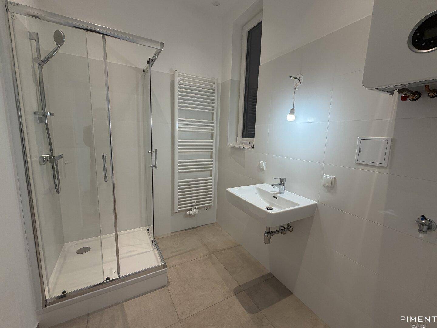 Modernes Badezimmer mit Duschkabine, Waschbecken, beheiztem Handtuchhalter und Wandfliesen.