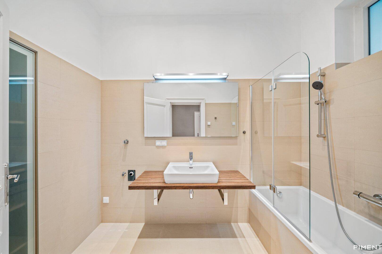Modernes Badezimmer mit Badewanne, Duschabtrennung und schwebendem Waschtisch.