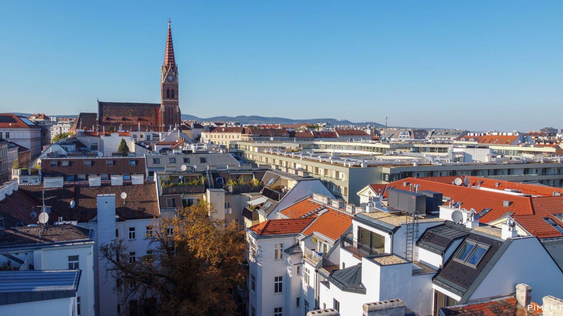 Panoramablick über die Stadt mit historischen Dächern und einer markanten Kirchturmspitze.