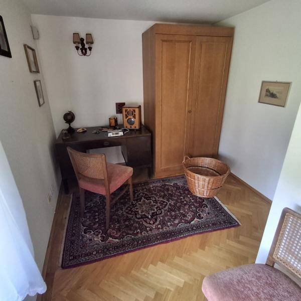 Arbeitszimmer mit Parkettboden, Schreibtisch und einem traditionellen Teppich.