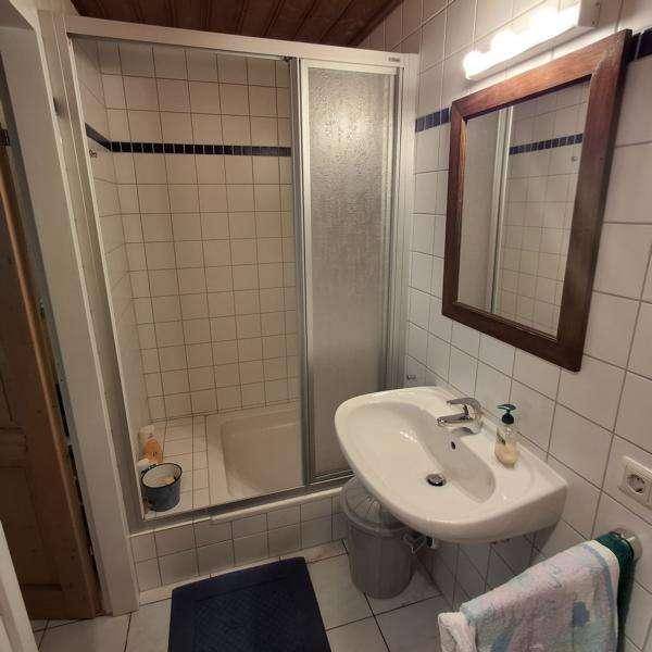 Badezimmer mit Duschkabine, Waschbecken und weißen Fliesen im traditionellen Stil.