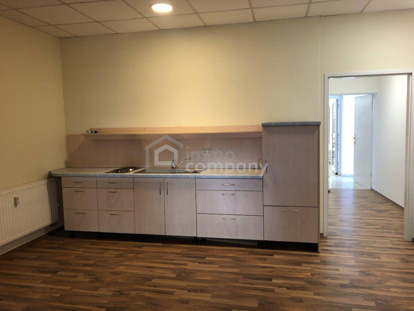 Funktionale Küchenzeile mit Spüle und Unterschränken, ideal für eine Büroküche oder kleine Wohnung.