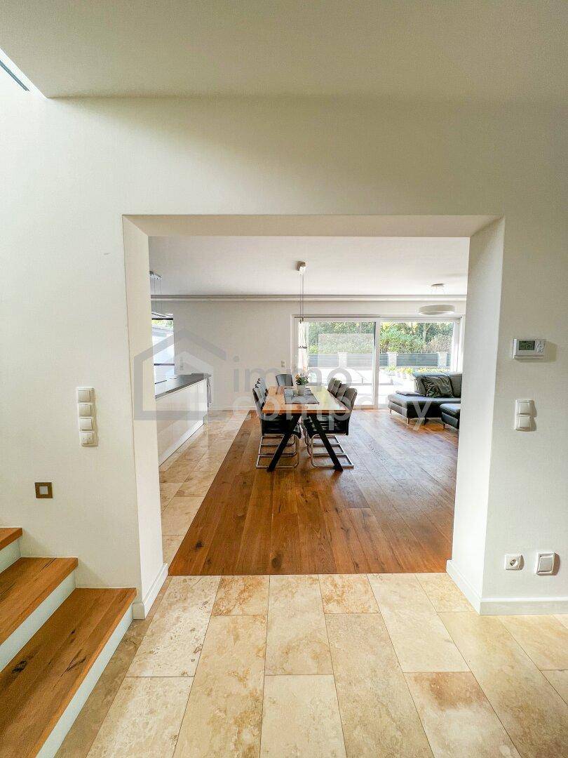 Heller, offener Wohn- und Essbereich mit Holzboden und Zugang zur Terrasse oder Garten.