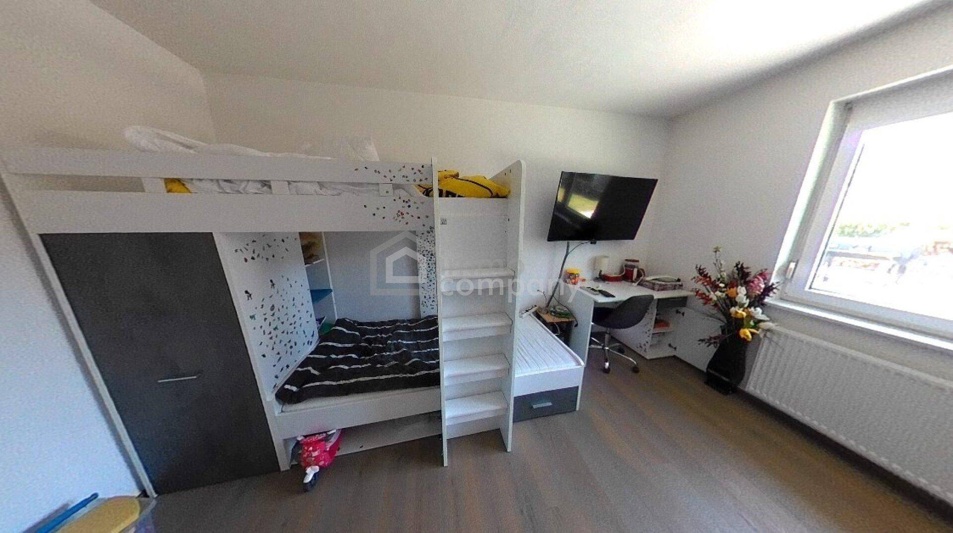 Kinderzimmer mit modernem Hochbett, Schreibtisch und großem Fenster für viel Tageslicht.