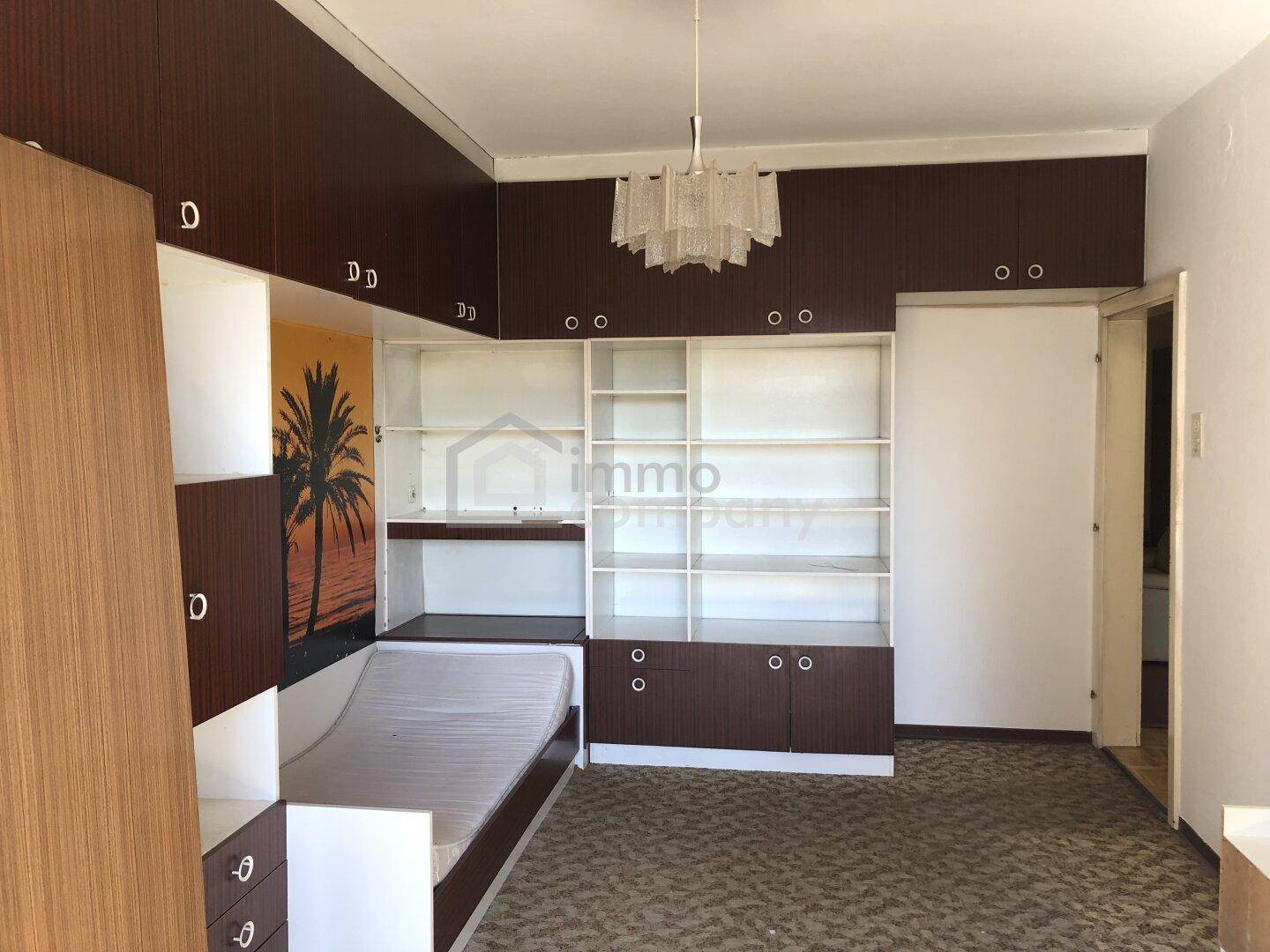Kinderzimmer oder Gästezimmer mit integriertem Bett, Regal und Schreibtisch.