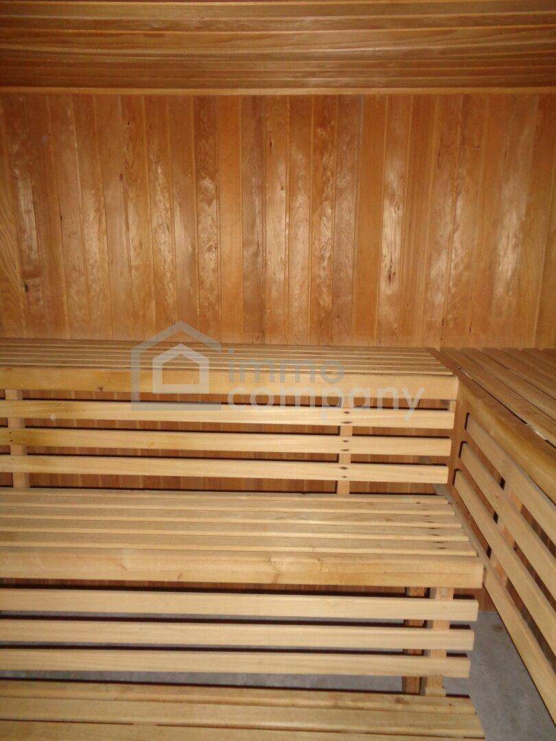 Holzverkleidete Sauna mit mehreren Sitzbänken, bereit zur Entspannung.