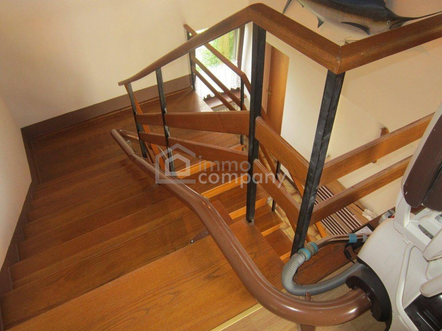 Holztreppe mit klassischem Geländer verbindet die Etagen des Hauses.