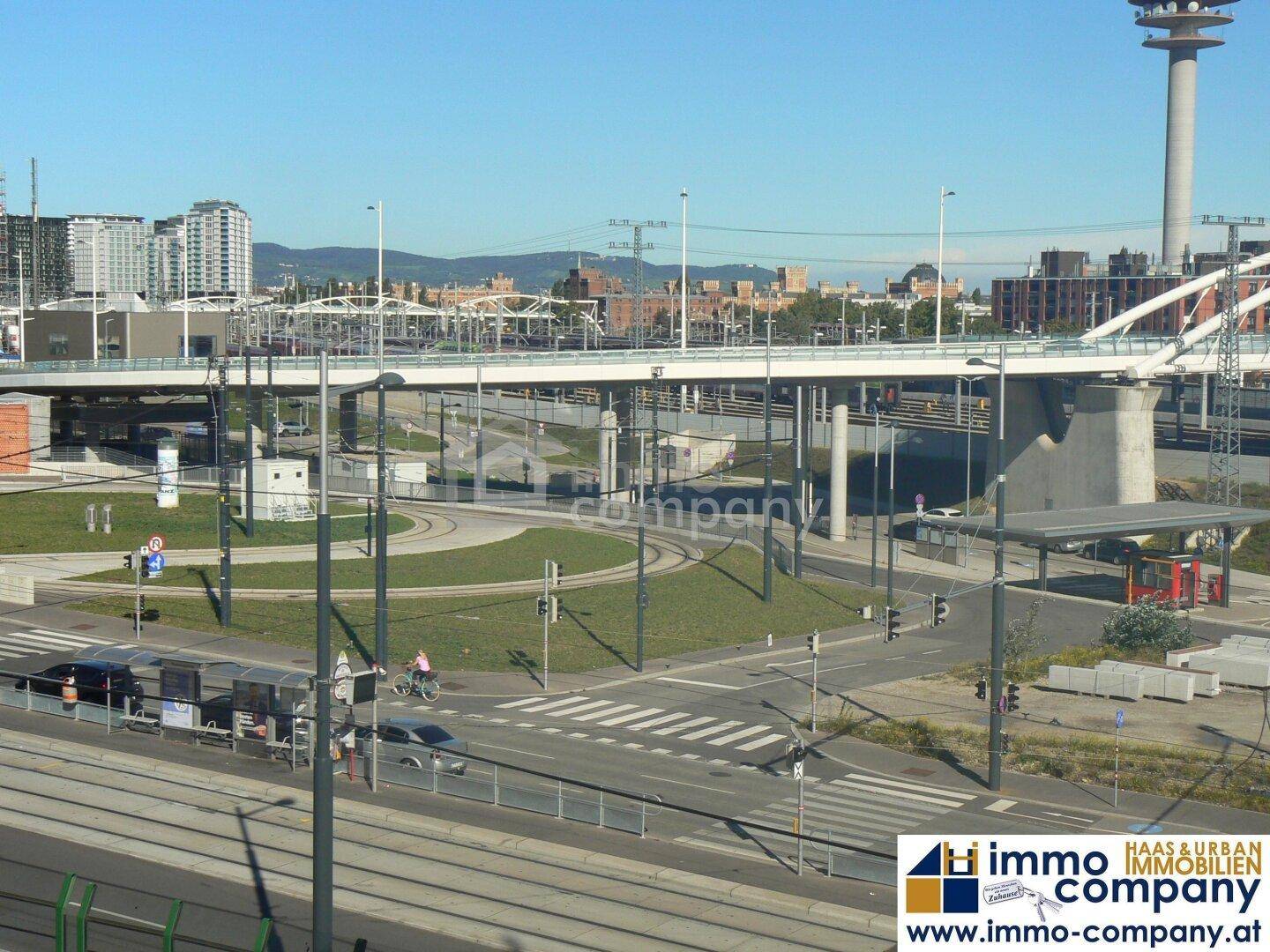 Städtische Ansicht mit einer Brücke, Straßen und Gebäuden im Hintergrund.
