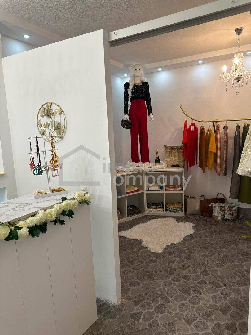 Verkaufsraum mit Schaufensterpuppe, Kleiderstange und Regalen für Modeartikel und Accessoires.