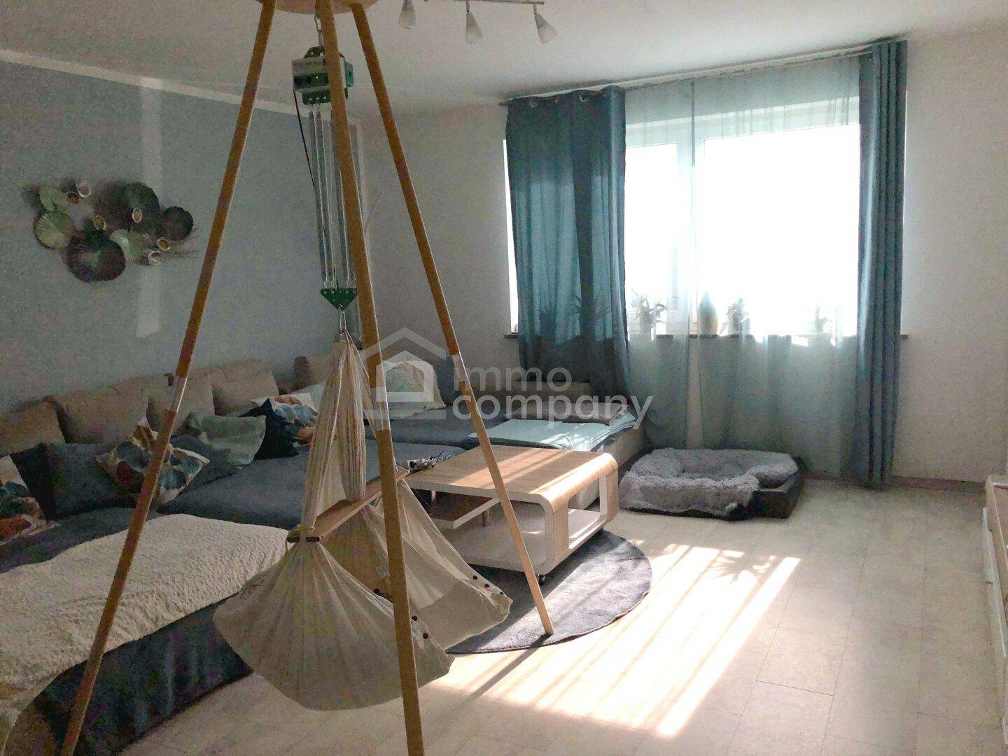 Gemütliches Wohnzimmer mit großem Sofa, Couchtisch und viel Tageslicht.