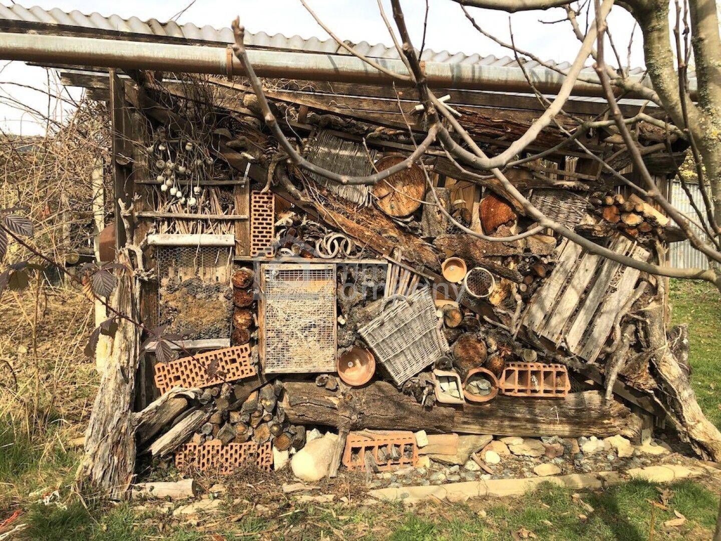 Kreatives Insektenhotel aus Holz und Naturmaterialien im Gartenbereich.