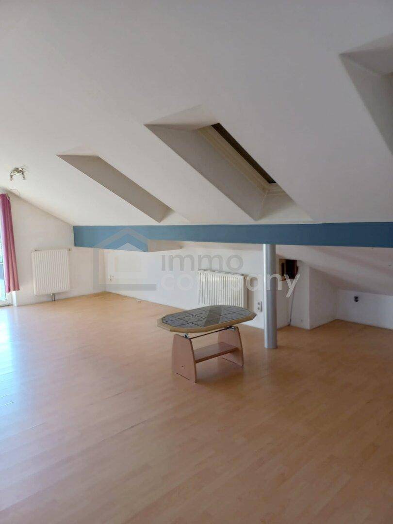 Geräumiges Dachzimmer mit schrägen Decken, Dachfenstern und hellem Laminatboden.