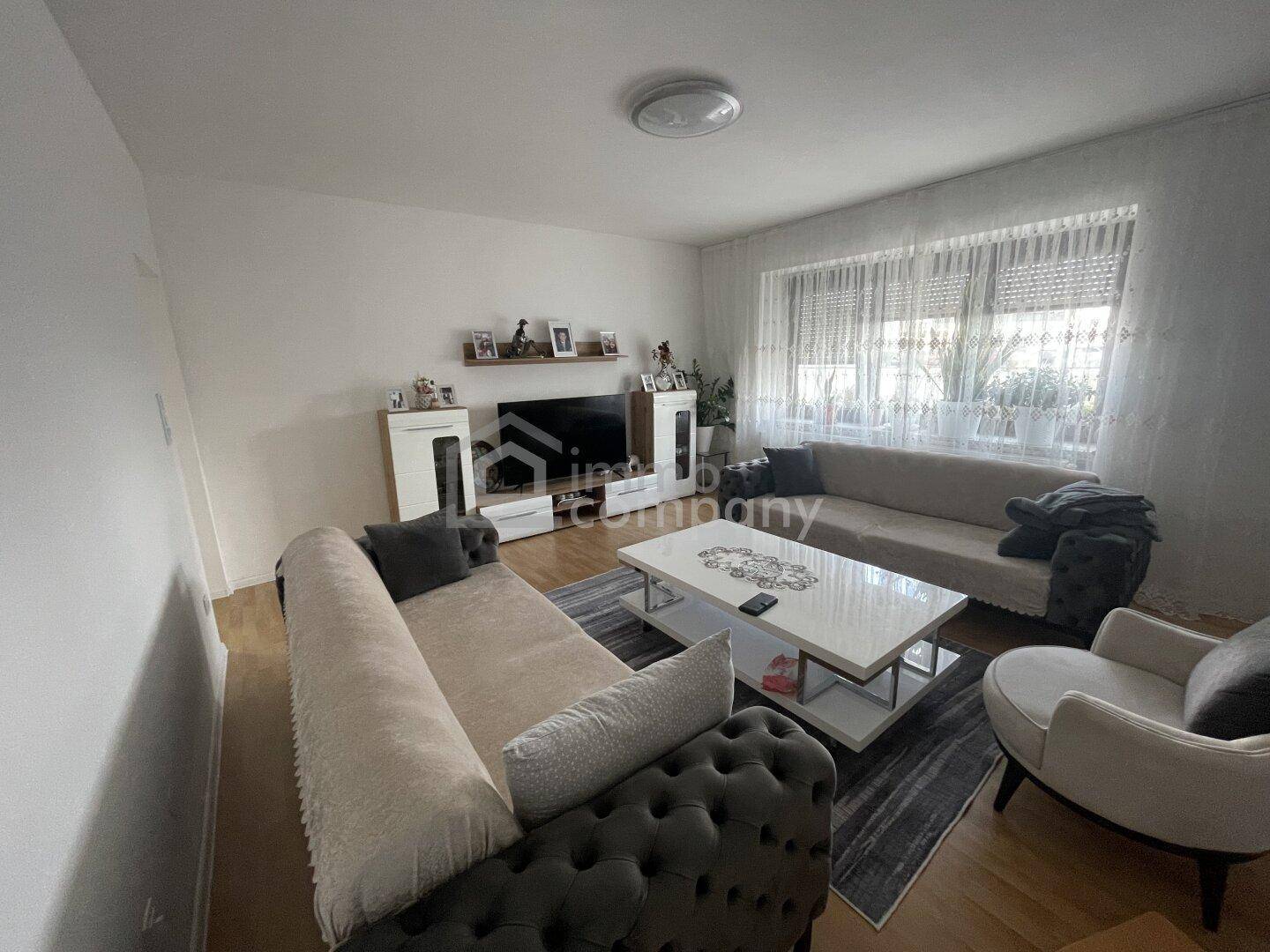 Gemütliches Wohnzimmer mit bequemen Sofas, Couchtisch und großem Fenster.