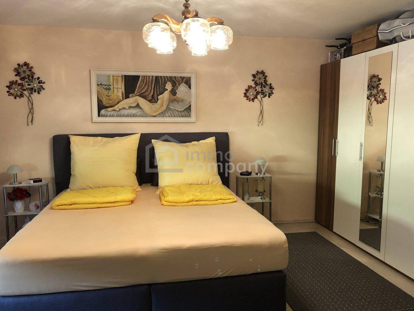 Gemütliches Schlafzimmer mit Doppelbett, Nachttischen und einem Kleiderschrank mit Spiegeltüren.