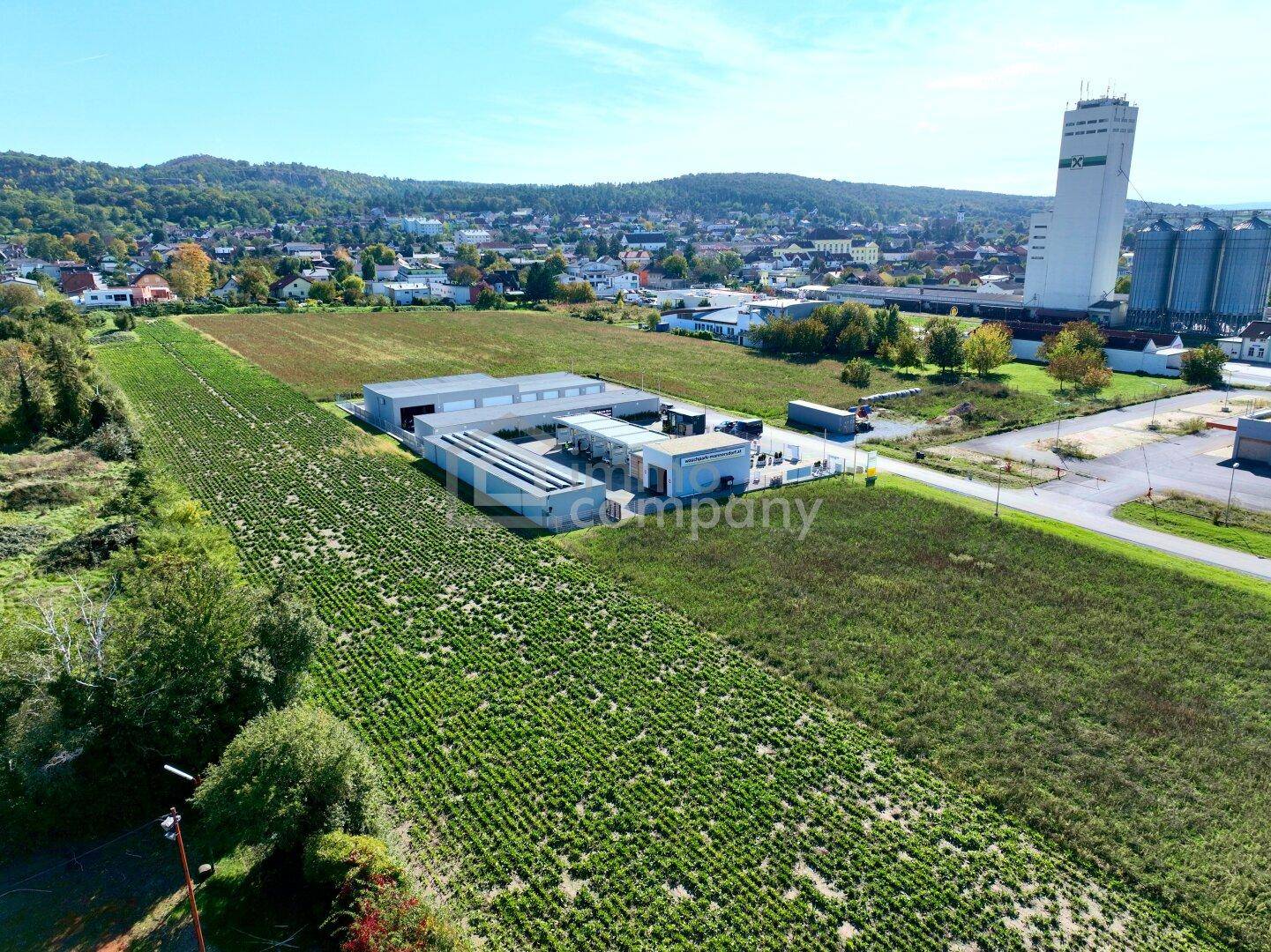 Luftaufnahme eines einzelnen Gewerbegebäudes umgeben von landwirtschaftlichen Feldern und einer weiten Landschaft.